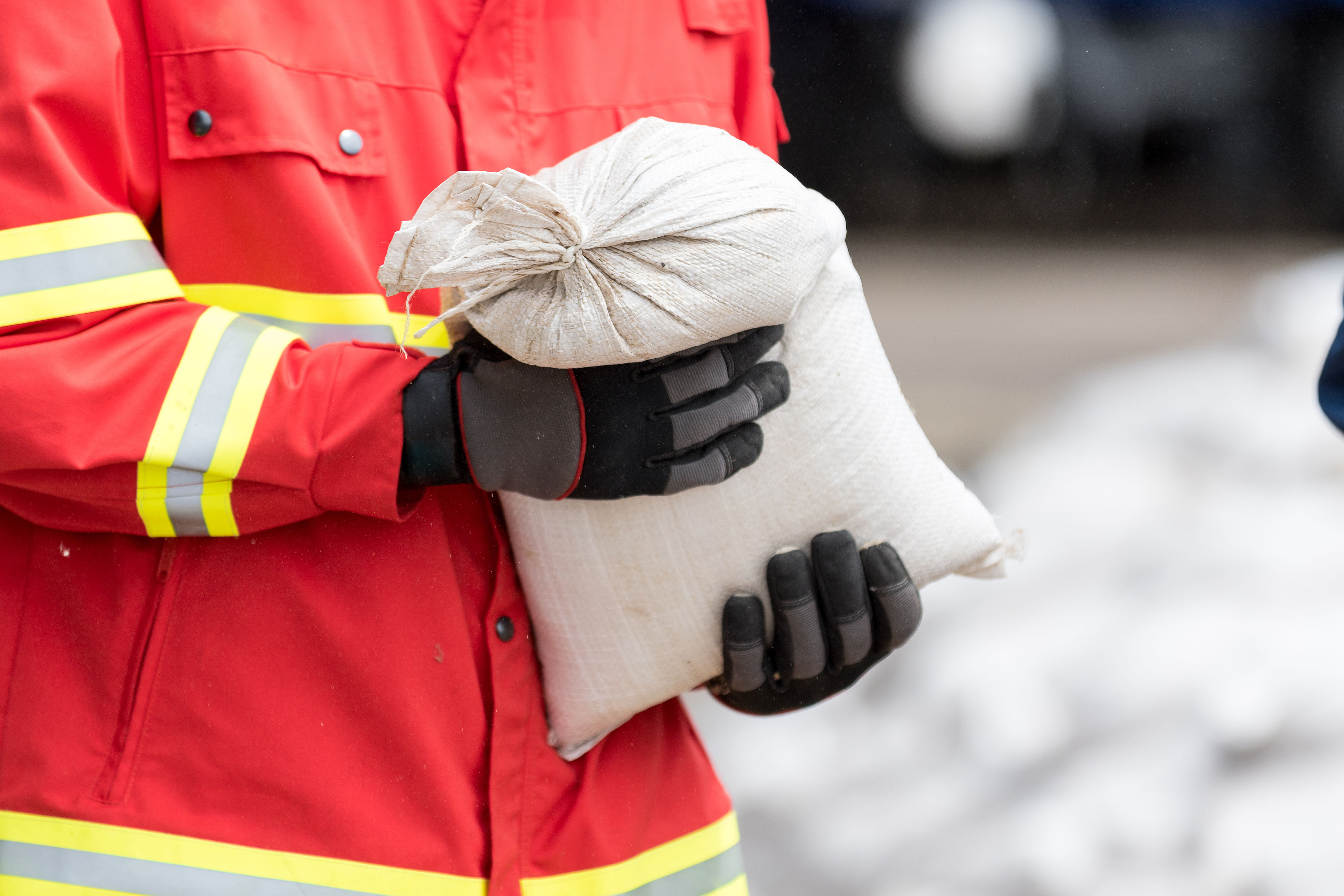 Helfer transportiert Sandsäcke